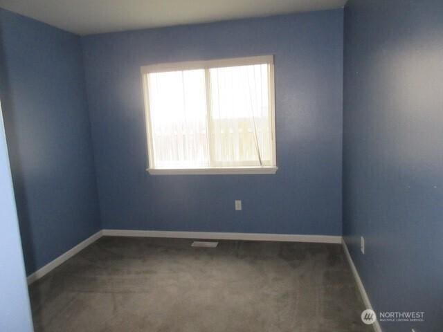 carpeted spare room featuring baseboards