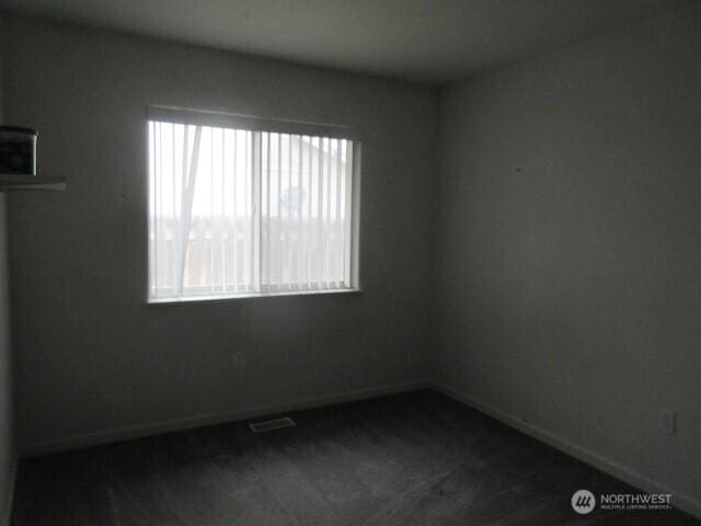 spare room with baseboards and visible vents