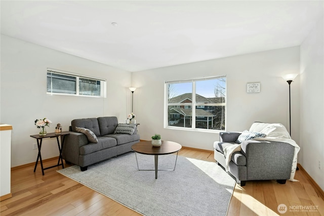 living area with baseboards and light wood finished floors