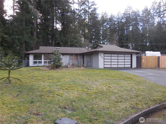 single story home with a garage, fence, aphalt driveway, and a front yard