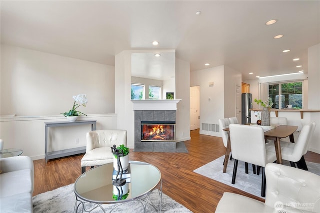 living area featuring a fireplace, wood finished floors, visible vents, and recessed lighting