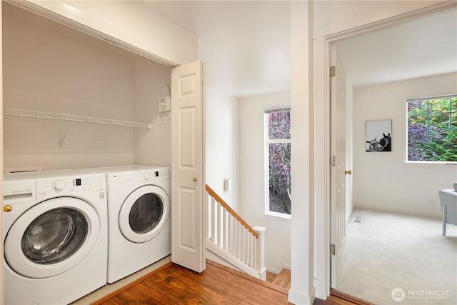 washroom featuring laundry area, independent washer and dryer, baseboards, and wood finished floors