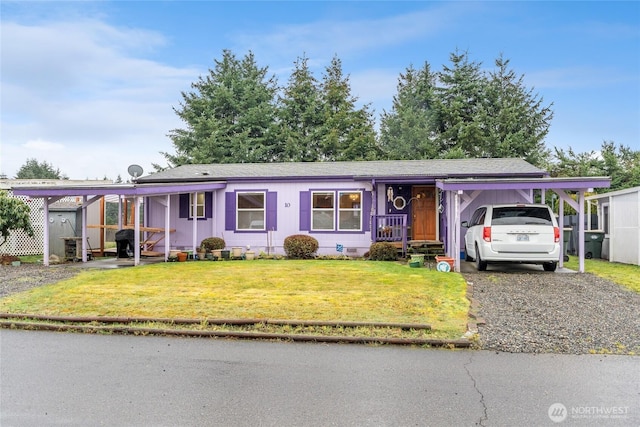 view of front of property featuring a front yard, crawl space, driveway, and an attached carport