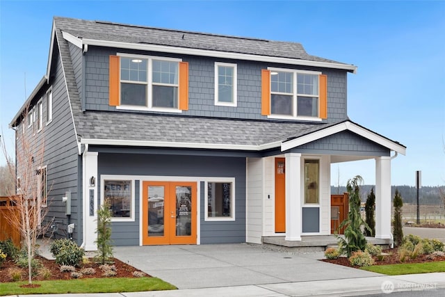 view of front facade featuring french doors and roof with shingles