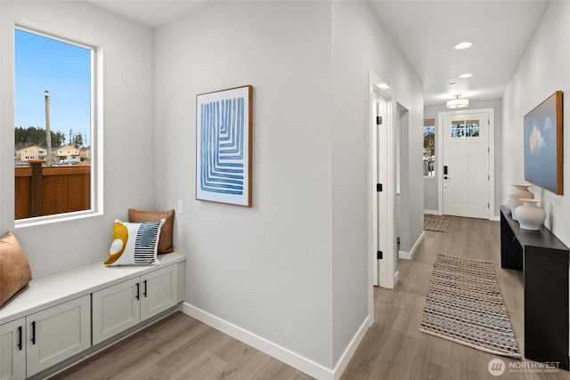 hallway with recessed lighting, light wood-type flooring, and baseboards