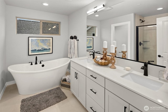 bathroom featuring double vanity, a soaking tub, a sink, and a shower stall