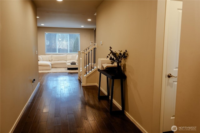 hall featuring dark wood-type flooring, recessed lighting, stairway, and baseboards