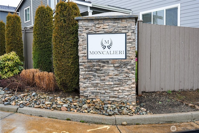 community / neighborhood sign featuring fence