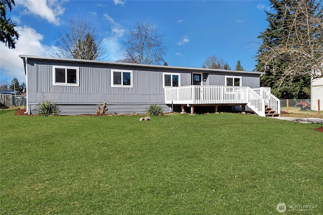 view of front of house featuring a front yard, a wooden deck, and fence