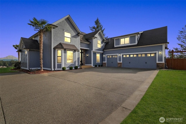 view of front of house featuring concrete driveway, stone siding, fence, and a front yard