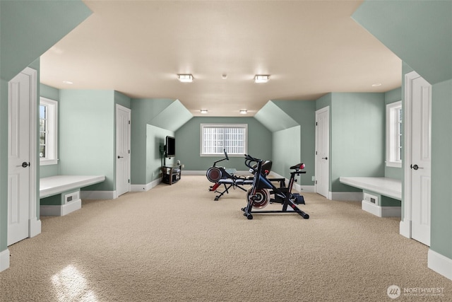 exercise area with lofted ceiling, carpet floors, and baseboards