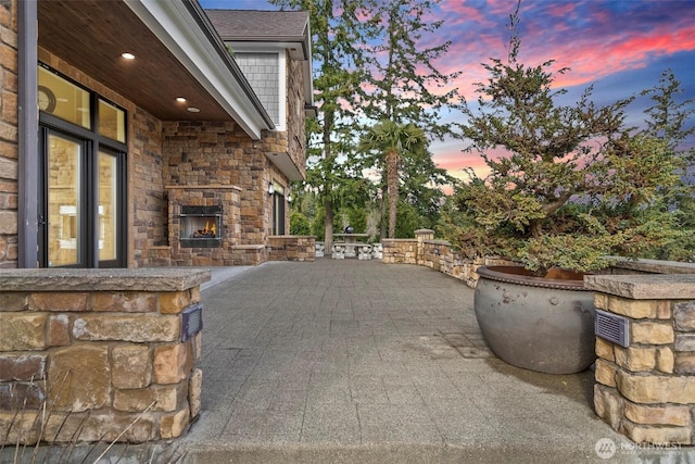 view of patio / terrace featuring an outdoor stone fireplace
