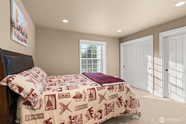 bedroom with recessed lighting, a closet, and light colored carpet