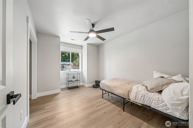 bedroom with ceiling fan, light wood-style flooring, visible vents, and baseboards