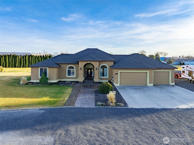 view of front of property featuring a front lawn, concrete driveway, an attached garage, and stucco siding