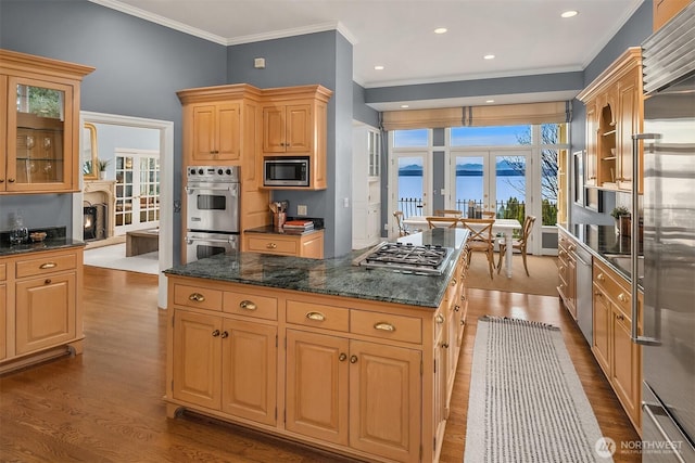 kitchen with dark wood-type flooring, a center island, french doors, and built in appliances