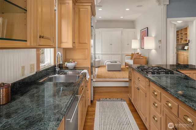 kitchen featuring recessed lighting, dark wood-type flooring, a sink, appliances with stainless steel finishes, and dark stone counters