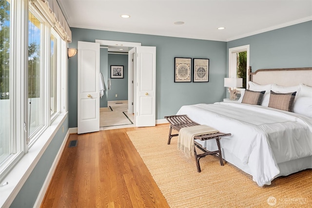 bedroom with crown molding, recessed lighting, baseboards, and light wood-style floors