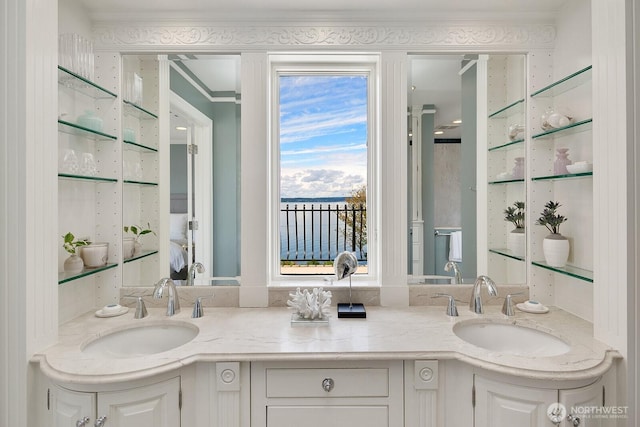 full bath featuring double vanity, a sink, a shower with shower door, and crown molding