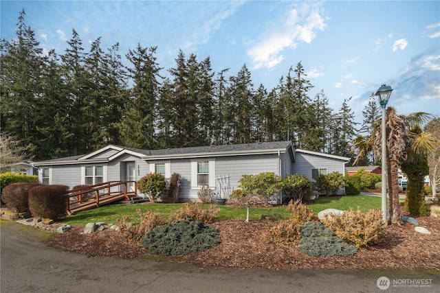 view of front facade featuring a deck and a front yard