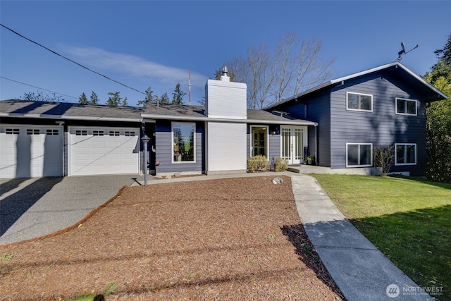 split level home featuring a garage, driveway, a chimney, and a front lawn