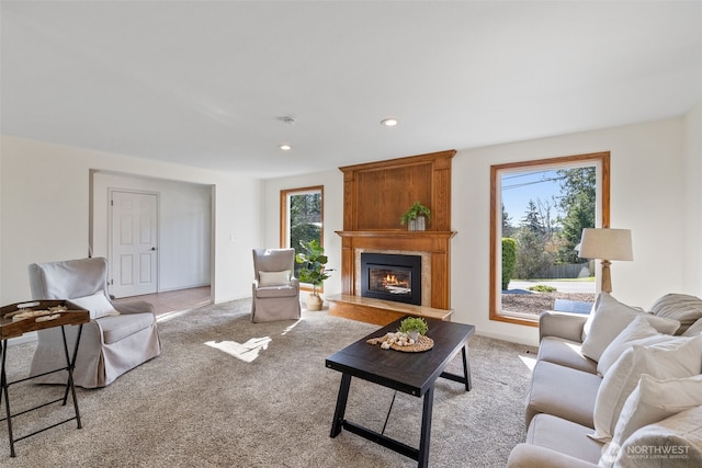 living area featuring recessed lighting, a fireplace, and light colored carpet