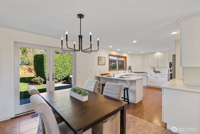 dining room featuring a chandelier, light tile patterned flooring, recessed lighting, visible vents, and french doors