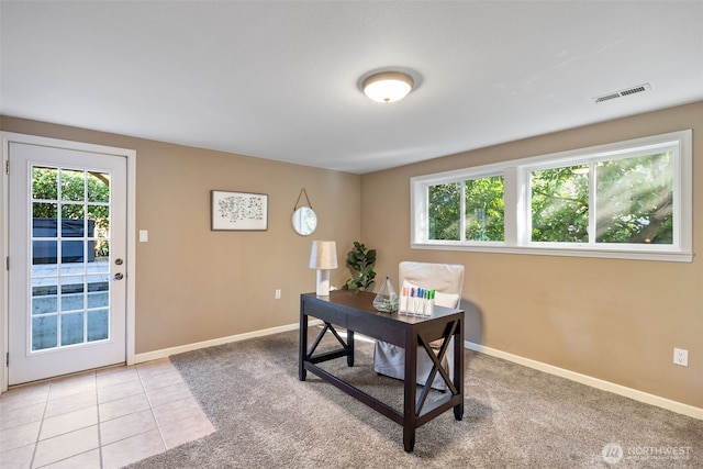 office space featuring light tile patterned floors, visible vents, and baseboards