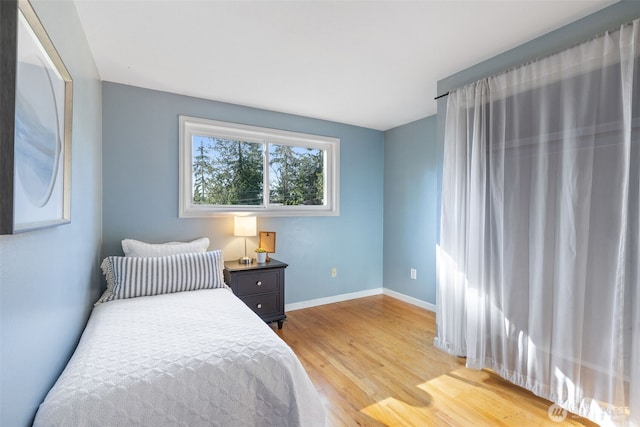 bedroom with light wood-style flooring and baseboards