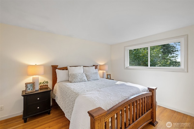 bedroom with light wood-type flooring and baseboards