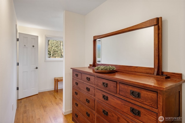 corridor featuring light wood-style floors and baseboards