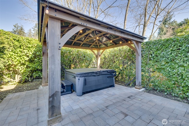 view of patio with a hot tub and a gazebo