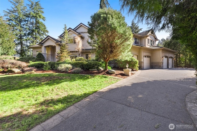 view of front of home with a front yard, stone siding, driveway, and stucco siding