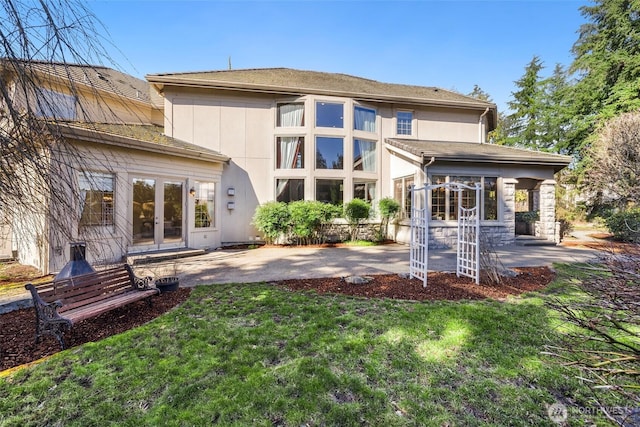 back of house featuring a yard, french doors, and a patio