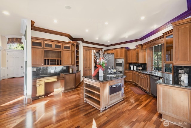 kitchen with open shelves, built in study area, a center island, and stainless steel appliances