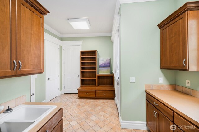 kitchen featuring brown cabinets, light countertops, and a sink