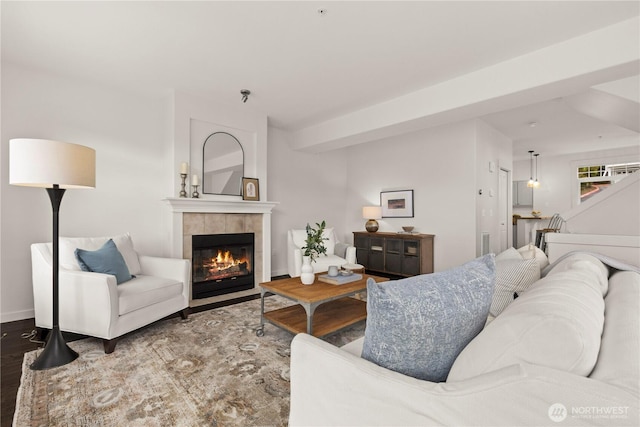 living area with a fireplace, baseboards, and wood finished floors