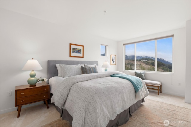 bedroom with baseboards, a mountain view, and light colored carpet