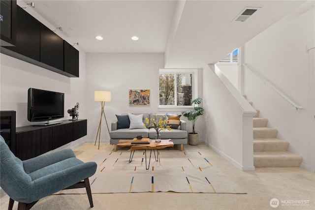 living room with recessed lighting, light carpet, visible vents, baseboards, and stairs