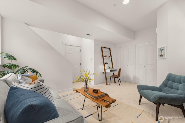 living area featuring light carpet, visible vents, baseboards, and stairs