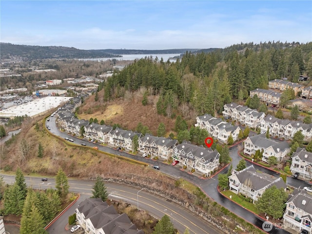 birds eye view of property featuring a residential view, a water view, and a wooded view