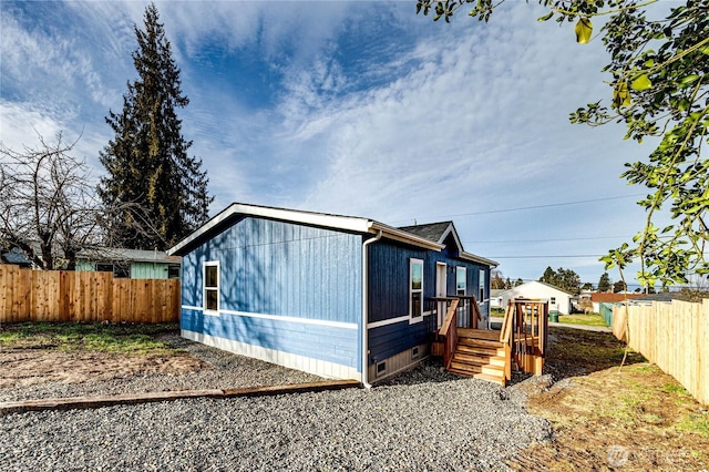 view of property exterior with a deck, crawl space, and fence