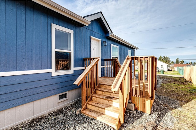 entrance to property featuring crawl space, fence, and a wooden deck