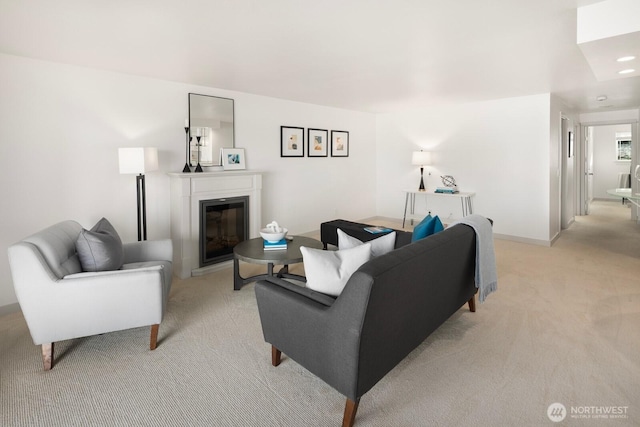 living area with light carpet, a glass covered fireplace, and recessed lighting