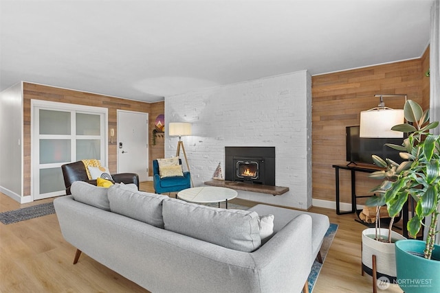 living area featuring a fireplace, wood finished floors, and wooden walls