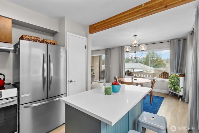 kitchen featuring a center island, freestanding refrigerator, light countertops, white electric range, and light wood-type flooring