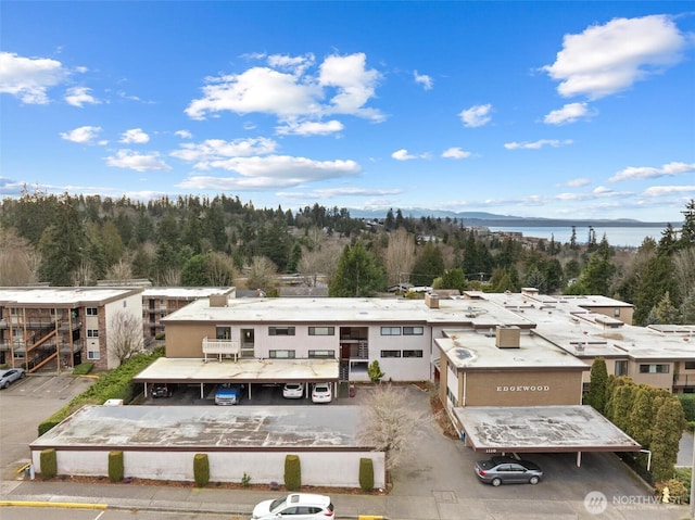 bird's eye view with a water view and a wooded view