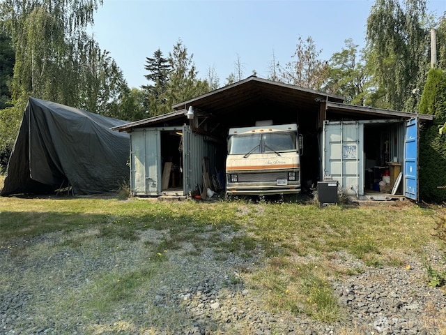 view of outdoor structure featuring driveway and an outbuilding