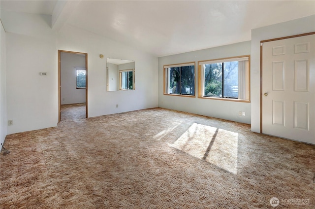 interior space featuring vaulted ceiling with beams, multiple windows, and carpet flooring