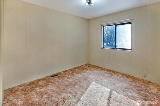 carpeted spare room featuring visible vents